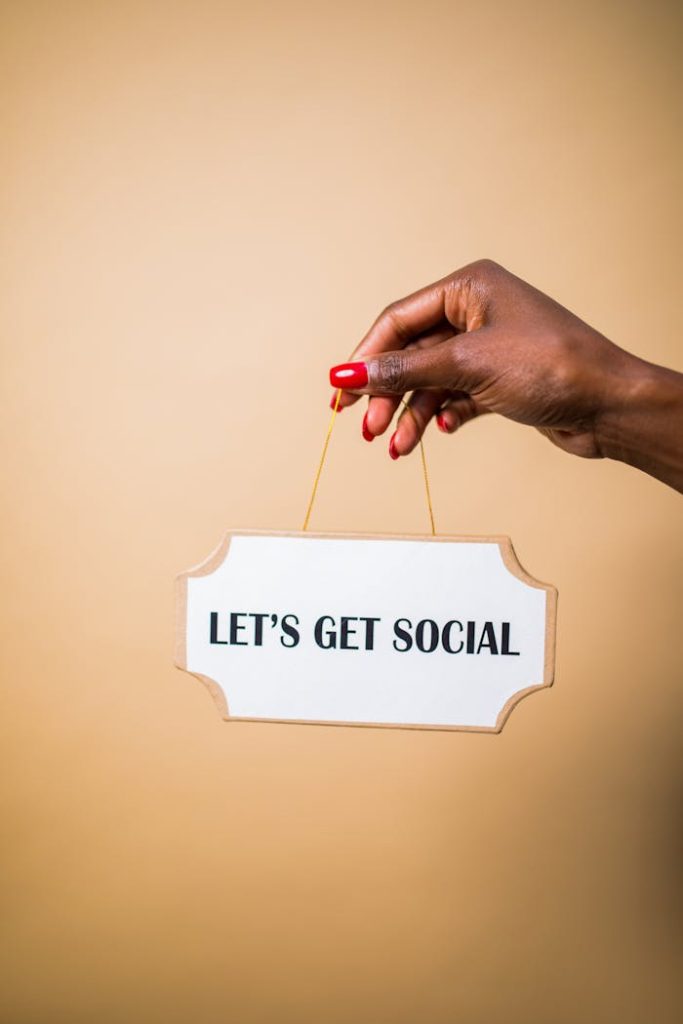 A hand holding a Lets Get Social sign, ideal for marketing and social media themes.